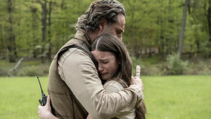 Rick and Judith hugging on The Walking Dead: The Ones Who Live.