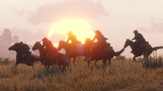 A group of cowboys ride across a grassy plain as the sun sets in the background