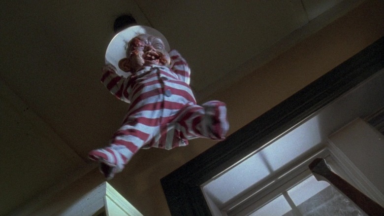 A monster baby hangs from a light fixture in Braindead.