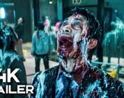 Zombie man with a blood-soaked face screaming in a crowded mall; foreground displays '4K TRAILER' text overlay.